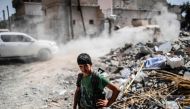A member of the Syrian Democratic Forces stands on a damaged street on the eastern frontline of Raqa on September 24, 2017.   AFP / BULENT KILIC
