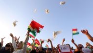Iraqi Kurds release doves during in a demonstration at Arbil airport, in the capital of Iraq's autonomous northern Kurdish region, after the central government ordered the indefinite halt to all foreign flights to and from Iraqi Kurdistan on September 29,