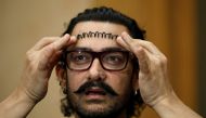 Actor Aamir Khan adjusts his hair during an interview in Singapore October 2, 2017. REUTERS/Edgar Su

