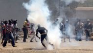 Protesters react to tear gas fired by riot policemen during a protest by opposition supporters against the retention of the election officials they blame for August's botched elections, in Kisumu, Kenya October 2, 2017. REUTERS/James Keyi
