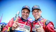 Qatar’s Nasser Saleh Al Attiyah (left) and his French navigator Matthieu Baumel gesture after victory in Morocco yesterday.