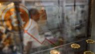 A man walking past a display cabinet containing models of Bitcoins in Hong Kong on August 3, 2016. (AFP / Anthony Wallace) 
