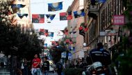 Flags of Italian football clubs Inter Milan and AC Milan are hanged in the Paolo Sarpi street, a chinese neighborhood of Milan, on October 13, 2017.  AFP / MIGUEL MEDINA
