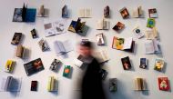A visitor walks past a book display at the Frankfurt Book Fair on October 13, 2017 in Frankfurt am Main, western Germany. France is this year's guest of honour at the world's largest book fair, where more than 7,000 exhibitors from more than 100 countries