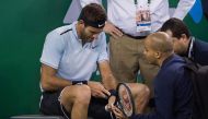 Juan Martin Del Potro of Argentina receives treatment after he fell during his men's singles quarter-final match against Viktor Troicki of Serbia at the Shanghai Masters tennis tournament in Shanghai on October 13, 2017. / AFP / NICOLAS ASFOURI
