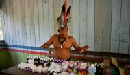 Chief Marcelino Apurina, of the Aldeia Novo Paraiso in the Western Amazon region of Brazil near Labrea stands by a table of modern medicines delivered to the village on September 21, 2017.  AFP / Carl De Souza