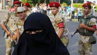 Army soldiers ask a female supporter of overthrown President Mohamed Mursi to take her protest to the sidewalk as they stand guard around Cairo University and Nahdet Misr Square in Giza, on the outskirts of Cairo, July 4, 2013. Reuters/ Asmaa Waguih