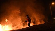 A firefighter tries to extinguish a fire in Cabanoes near Louzan as wildfires continue to rage in Portugal on October 16, 2017.  AFP / Francisco LEONG
