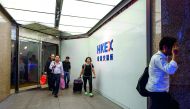 In this picture taken on October 19, 2017, Cheng (C), a trader who worked on the floor since 1994, leaves the Hong Kong Stock Exchange after finishing her last day of work as a floor trader. AFP / Anthony Wallace 