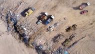 An aerial view shows garbage trucks dumping rubbish at the Kotsiatis landfill on the outskirts of the Cypriot capital Nicosia on August 30, 2017.  AFP / STRINGER
