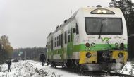 Passengers walk near the railroad crossing at the site of a crash between a train and a military truck on October 26, 2017 near Raseborg, southern Finland. / AFP.