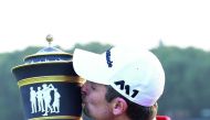 Justin Rose of England kisses his trophy after he stormed back from eight shots behind overnight to win the $9.75m WGC-HSBC Champions by two strokes in a thrilling finale at the Sheshan International golf club in Shanghai yesterday.