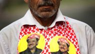 An Iraqi Kurd wears a scarf bearing a portrait of the Iraqi Kurdish leader Massud Barzani, during a protest in support of him, in Arbil, the capital of autonomous Iraqi Kurdistan, on October 30, 2017.  AFP / SAFIN HAMED
