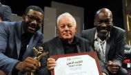 Director Licinio Azevedo (C), flanked by actors Matamba Joaquim (L) and Thiago Justino, poses after receiving the Tanit d'Or award for his film 