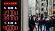 People stay in frot of a money exchange office on November 21, 2017 in Istanbul. The Turkish lira hit record lows in value against the US dollar on November 21 as investors took fright over an impending trial in the United States and changes to banking re