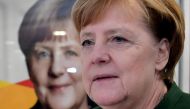 German Chancellor Angela Merkel walks past a poster of herself as she arrives to give a press conference on November 27, 2017 in Berlin, following a meeting with her conservative Christian Democratic Union (CDU) party's leadership.  AFP / John MACDOUGALL