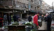 People gather at a damaged site after an airstrike in the rebel-held besieged town of Douma, eastern Ghouta in Damascus, Syria, November 27, 2017. REUTERS/Bassam Khabieh
