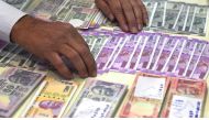 Numismatist Vijay Pal arranges Indian currency notes at the INPEX- 2017 National Philatelic Exhibition in Mumbai on November 30, 2017. / AFP / INDRANIL MUKHERJEE
