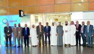 QIB officials pose in front of the Hamad International Airport branch of the bank.