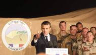 French president Emmanuel Macron gestures as he speaks to 700 French soldiers of Barkhane forces on December 22, 2017 during a visit at the French air force base in Niamey. / AFP / ludovic MARIN