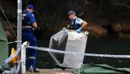 A policewoman holds a piece of debris from the seaplane that crashed.PHOTO: REUTERS.