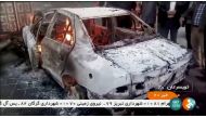 People stand near a burning car in Tuyserkan, Hamadan Province, Iran, December 31, 2017 in this still image taken from video. IRINN/ReutersTV via REUTERS