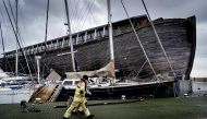 Workers walk past the Museum ship De VerhalenArk after it got loose in heavy winds at the harbour in Urk on January 3, 2018, as Storm Eleanor swept over the country. AFP / ANP / Robin van Lonkhuijsen