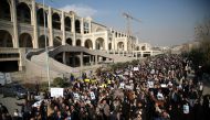 Iranians hold placards during a protest after performing the Friday Prayer at Imam Khomeini Mosque following US' statement about backing the anti-government protests in Tehran, Iran on January 05, 2018. (Fatemeh Bahrami - Anadolu Agency).