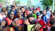 Fans take a selfie with Sir Mo Farah at the Ooredoo Doha Marathon 2018 in Doha yesterday. Right: Children taking part in the special 1 KM fun run pose for a picture.  Pictures: Kammutty VP / The Peninsula