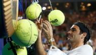 Roger Federer of Switzerland signs autographs during Kids Tennis Day before the Australian Open tennis tournament. REUTERS/Thomas Peter

