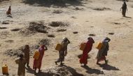 Women carry jerry cans of water from shallow wells dug from the sand along the Shabelle River bed which is dry due to drought in Somalian Shabelle region, March 19, 2016. Reuters / Feisal Omar