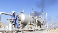 FILE PHOTO: A worker checks the valve of an oil pipe at Nahr Bin Umar