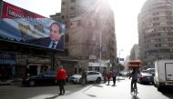People walk by a poster of Egypt's President Abdel Fattah al-Sisi from the campaign titled 