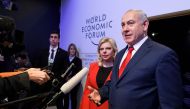 Israeli Prime Minister Benjamin Netanyahu talks to journalist next to his wife Sara during the World Economic Forum (WEF) annual meeting on January 25, 2018 in Davos, eastern Switzerland. AFP / Fabrice Coffrini