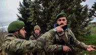 Turkish-backed Syrian rebel fighters take a position as they stand guard near the frontline on January 26, 2018 at the Syrian town of Azaz.  AFP / OZAN KOSE