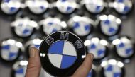 An employee holds a BMW logo on the production line of the BMW C evolution electric maxi-scooter at the BMW Berlin motorcycle plant, February 23, 2015. (Reuters / Fabrizio Bensch) 
