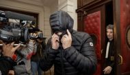 A man covers his face as he leaves the court during the first session of the 2013 Brussels Airport diamond heist case at the Brussels criminal court on January 31, 2018, in which sixteen men and three women are accused. AFP / Belga / Thierry Roge