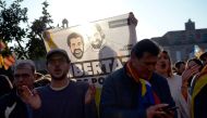 A protester holds a banner depicting images of Catalan separatist leaders Jordi Cuixart and Jordi Sanchez during a demonstration outside the Catalan Parliament on January 30, 2018 in Barcelona. AFP / Josep LAGO

