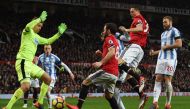 Huddersfield Town's Danish goalkeeper Jonas Lossl (L), Manchester United's Spanish midfielder Juan Mata (C) and Manchester United's Serbian midfielder Nemanja Matic (2R) scramble for the ball in the Huddersfield goal mouth during the English Premier Leagu