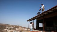 Men work on the roof of a house under construction in the unauthorised Jewish settler outpost of Havat Gilad, south of the West Bank city of Nablus November 5, 2013. Reuters/Nir Elias