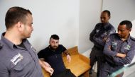 Mohammed Harouf, a Palestinian who pleaded guilty to the murder of a pregnant Jewish settler, sits in court accompanied by Israeli Prison Authority guards, in Tel Aviv, Israel February 4, 2018. Reuters/Nir Elias