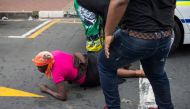 ANC (African National Congress) members attack a woman they suspect of being a member of the BLF (Black Land First) movement, outside the ANC headquarters in Johannesburg on February 5, 2018. AFP / Wikus De Wet