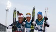 Sweden's Charlotte Kalla (C), flanked by Norway's Marit Bjoergen (L) and Finland's Krista Parmakoski celebrate at the end of the women's 7.5km + 7.5km cross-country skiathlon event at the Alpensia cross country ski centre during the Pyeongchang 2018 Winte