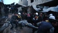 Members of Syrian civil defence forces known as the White Helmets evacuate a victim of an air strike in the rebel-held enclave of Arbin in the Eastern Ghouta near the capital Damascus on February 9, 2018. AFP / ABDULMONAM EASSA