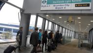 FILE PHOTO: Passengers alight from a train to enter City Airport in London, Britain, October 18, 2017. REUTERS/Toby Melville/File Photo	

