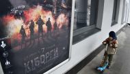 A boy passes a poster of the Ukrainian blockbuster film 
