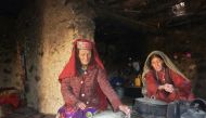 This photograph taken on October 8, 2017 shows Afghan Wakhi nomadic woman Sultan Begium (L) and her daughter-in-law preparing food inside their mud home in the Wakhan Corridor in Afghanistan. AFP / Gohar Abbas