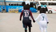 Supporters dressed as Paris Saint-Germain's Brazilian forward Neymar Jr and Real Madrid's Portuguese forward Cristiano Ronaldo walk outside the Santiago Bernabeu stadium in Madrid on February 14, 2018 hours before the Champions' League football match Real