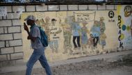 A man walks past an Oxfam sign in Corail, a camp for displaced people of the 2010 earthquake, on the outskirts of Port-au-Prince, Haiti, February 13, 2018. Reuters/Andres Martinez Casares