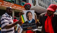 Supporters of the Zimbabwe opposition party Movement for Democratic Change (MDC) hold banners of Morgan Tsvangirai reading 